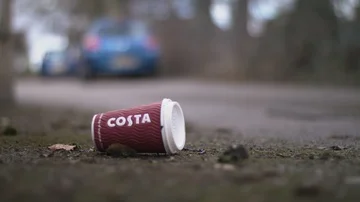 Picking up discarded coffee cup from the floor Stock Footage 85843388