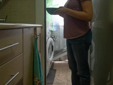 Picking up the dishwasher in the kitchen Stock Photos
