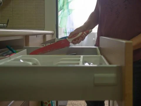 Picking up the dishwasher in the kitchen Stock Photos