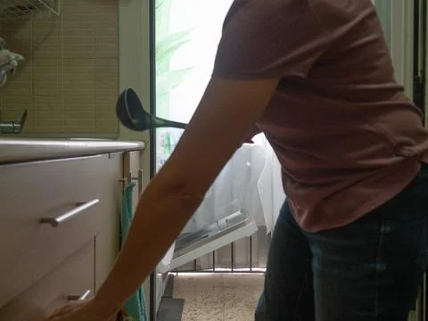 Picking up the dishwasher in the kitchen Stock Photos