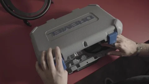 Picking up a Dremel tool from a box Stock Footage 125446415