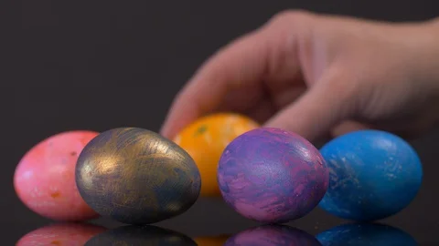 Picking Up Easter Eggs on Black Background. Easter Stock Footage 129203680