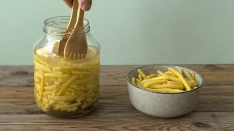 Picking fermented yellow wax beans from jar with wooden tongs, static view Stock-Footage 343891287