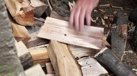 Picking up firewood from a stack of dry wood, strong man hands, firing Stock Footage 41265655