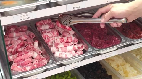 Picking fresh sliced meat and an egg in Chinese hot pot in restaurant trays.. Video stock 340469589