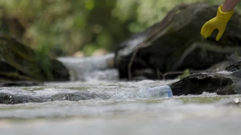 Picking up garbage water plastic nature. Volunteer cleaning river trash pick up Stock Footage 191914679