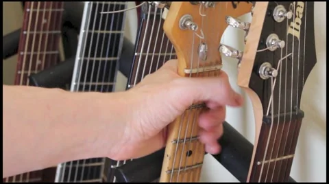Picking up guitar form guitar rack Stock Footage 49408485