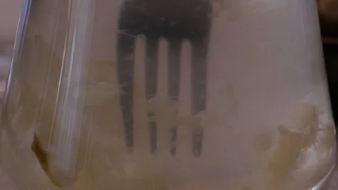 Picking a lemon slice with a fork from a glass container filled with fresh Video stock 115921204