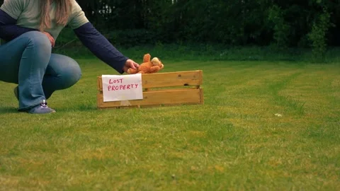 Picking up lost children toy teddy bear from lost property box Vídeo Stock 334651637