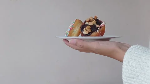 Picking one donut on a plate full of donuts Stock Footage 149956639