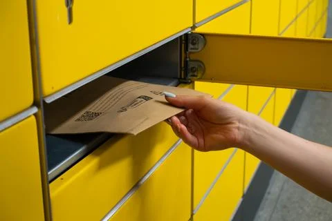 Picking up a Package From a Yellow Parcel Locker Stock Photos