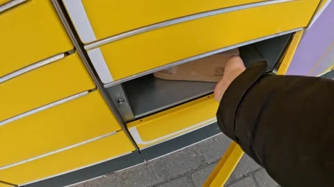 Picking up parcel from yellow post machine, POV view Stock Footage 309567561