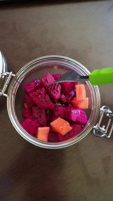 Picking a piece of dragon fruit with a fork from a bowl with tropical fruit Stock Footage 301231239