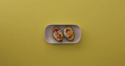 Picking up plate of cooked avocado, eggs, and bacon 1 Video stock 132149572