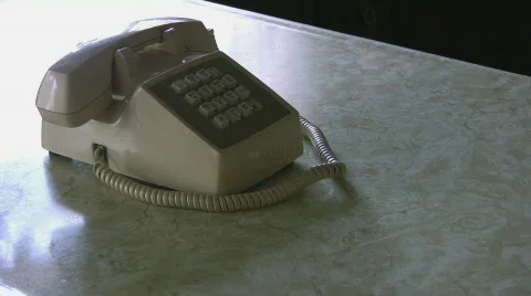 Picking up receiver on an old push button phone Stock Footage 576926
