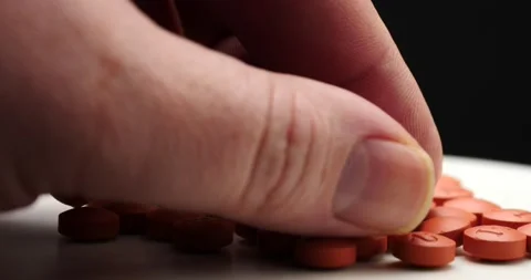 Picking up red pill on spinning table close up isolated Stock Footage 169831529