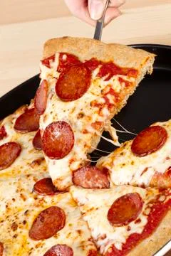 Picking a slice of pepperoni pizza Stock Photos