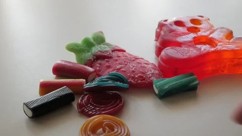 Picking some different colors jellies and licorice on a table in studio 스톡 동영상 280756752