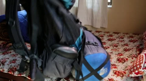 Picking up a trekking backpack Stock Footage 65775280