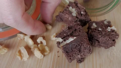 Picking Walnuts with Chocolate Treats Close Up on Wooden Surface Stock Footage 333667547