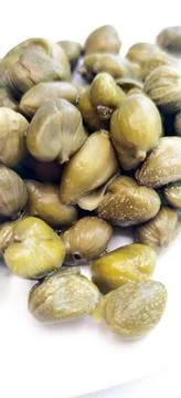 Pickled capers as a background. Pickled caper buds. Stock Photos