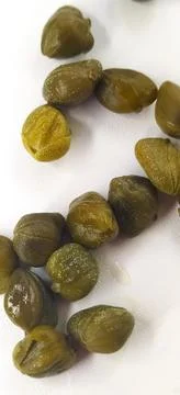 Pickled capers as a background. Pickled caper buds. Stock Photos