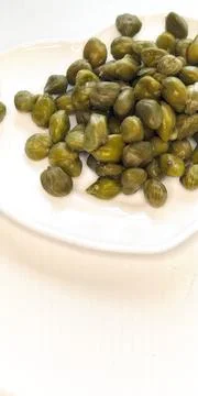 Pickled capers as a background. Pickled caper buds. Stock Photos