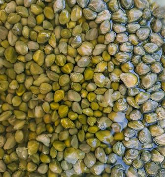 Pickled capers showcasing vibrant texture in a close-up view of brine-soake.. Stock Photos