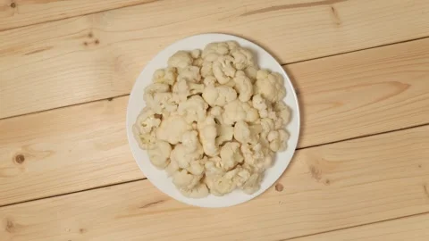 Pickled cauliflower florets rotating on a plate Видео 338312337