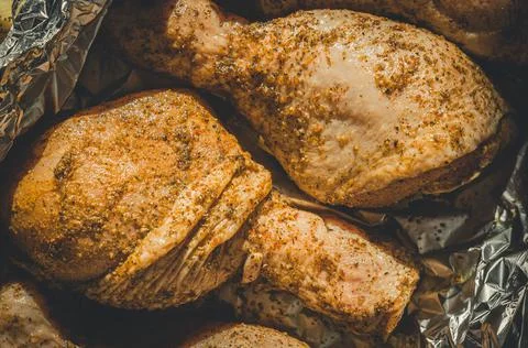 Pickled chicken legs in foil for baking. Cooking in the oven. Close-up Stock Photos