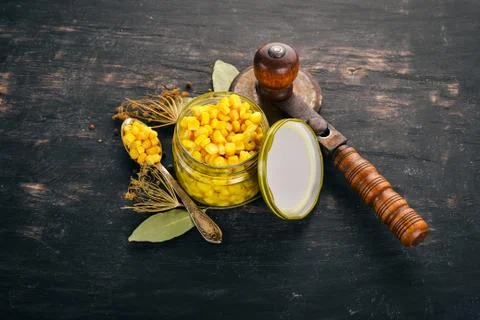Pickled corn in a jar. Stocks of food. Top view. On a wooden background. Copy Stock Photos