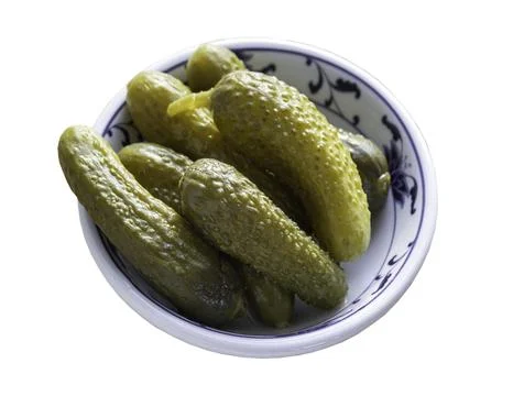 Pickled Cornichons in Vinegar on Ceramic cup isolated on white background w.. Stock Photos