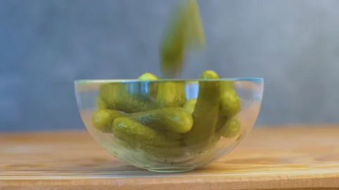 Pickled cucumber fallen down into glass bowl Stock Footage 145719591