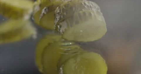 Pickled cucumber falling on a mirror surface Stock Footage 197702403