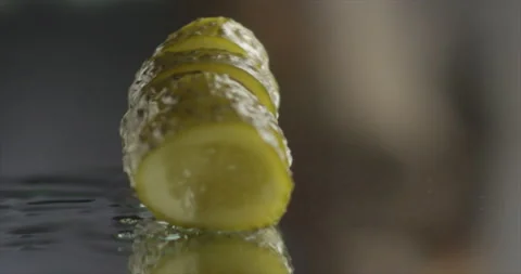 Pickled cucumber spinning on a mirror surface Stock Footage 198560600