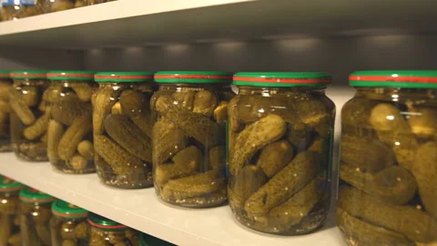 Pickled cucumbers in banks stand on the shelf in store. Video stock 100706554