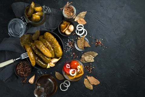 Pickled cucumbers in a ceramic round plate on a black background. Stock Photos