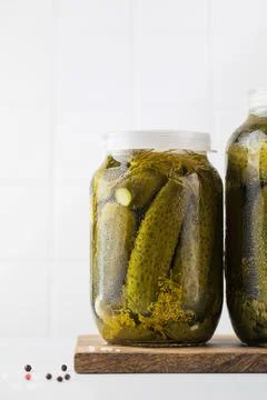 Pickled cucumbers in jars on a white background. Canning vegetables. Copy space. Foto stock