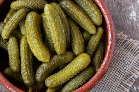 Pickled gherkins on rustic background Stock Photos