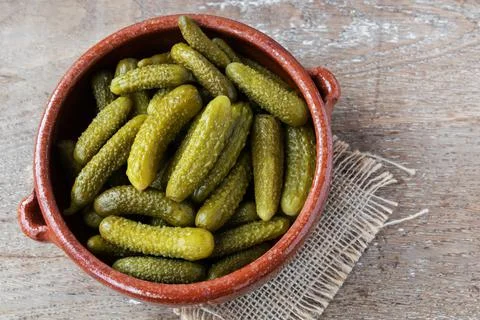 Pickled gherkins on rustic background Stock Photos