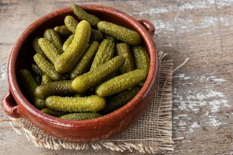 Pickled gherkins on rustic background Stock Photos