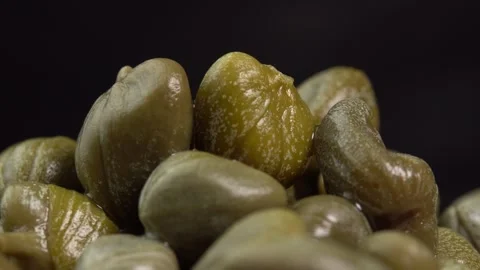 Pickled marinated capers rotate in macro on black background. Ingredients for Stock Footage 244811741