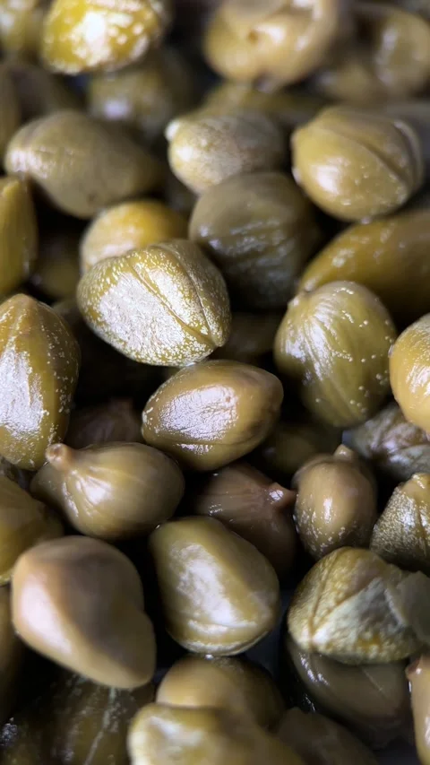 Pickled marinated green capers close up, rotation Stockbeeldmateriaal 296482985