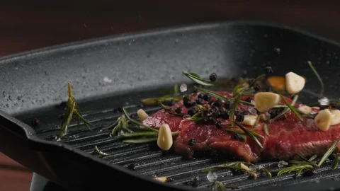 Pickled piece of meat is throwing to pan and seasoned with salt and pepper Stock Footage 123573187