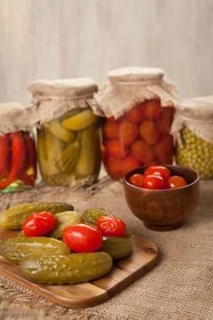 Pickled preserved vegetables in jars, cucumbers, pepper, tomatoes and peas Stock Photos