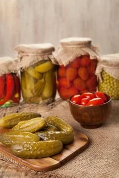 Pickled preserved vegetables in jars, cucumbers, pepper, tomatoes and peas Stock Photos