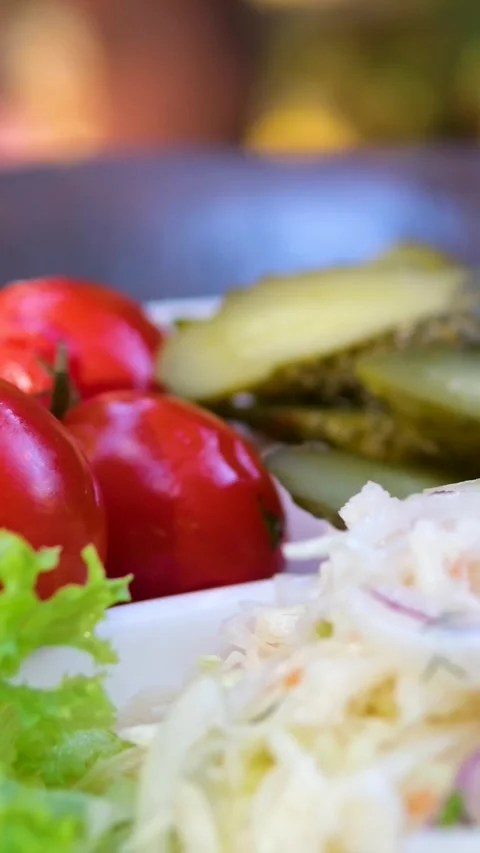 Pickled tomatoes, cucumbers and cabbage on a plate Set of chopped fermented Stock Footage 320724282