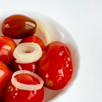 Pickled tomatoes in a white plate. Stock Photos