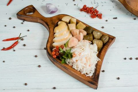 Pickled vegetables on a plate on white table with spices on background tradit 스톡 사진