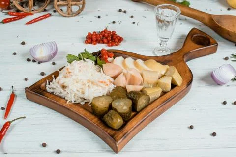 Pickled vegetables on a plate on white table with spices on background tradit Stock Photos